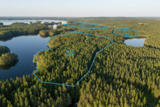 Ilmakuva alueesta ja yleiskaavan RM-4 kortteleista, metsää ja järveä.