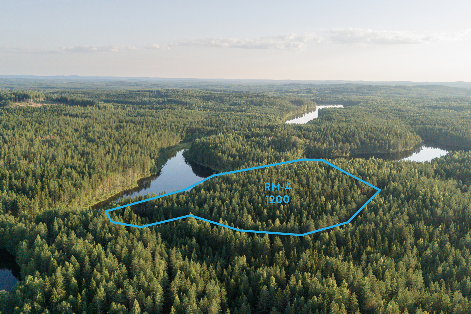 Ilmakuva alueesta ja yleiskaavan RM-4 kortteleista, metsää ja järveä.